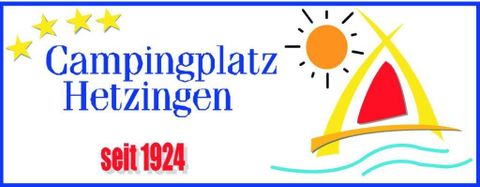 Campingsite Hetzingen met een kleurrijk logo dat zon, water en een zeilboot afbeeldt. De plek is sinds 1924 in gebruik.