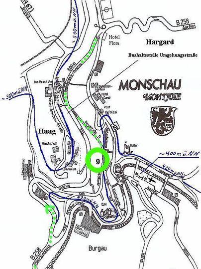 A map of Monschau with marked streets and important points. The green line indicates a route, the place is known for its picturesque old town.