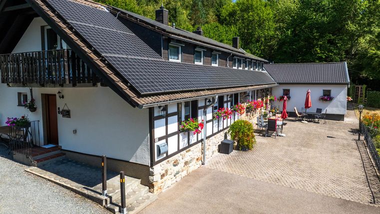Een charmant huis omringd door groene natuur. De terras is uitgerust met planten en meubels, ideaal voor ontspannen uren buiten.