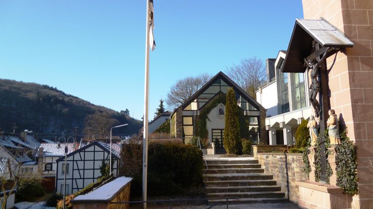 Eine malerische Landschaft mit einem historischen Gebäude und Treppen. Der klare Himmel und die umgebende Natur verleihen der Szene einen ruhigen Charme.