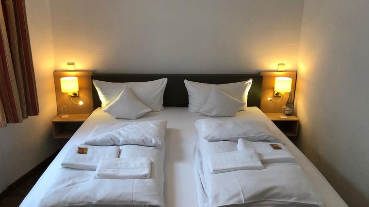 A cozy bedroom with a double bed and two nightstands. The lighting is warm and inviting.