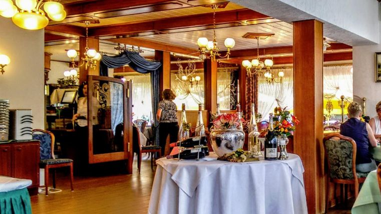 Een gezellig restaurant met een elegante inrichting. Tafels zijn ingericht en de sfeer is uitnodigend.