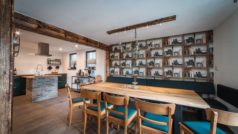 Een moderne keuken met houten planken en een grote eettafel. De inrichting is gezellig en uitnodigend.