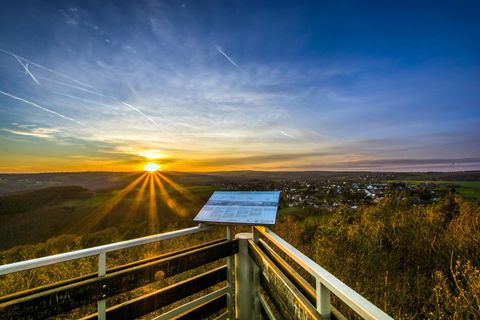 Ein wunderschöner Sonnenuntergang über einer malerischen Landschaft. Die Sonne strahlt durch den Himmel und beleuchtet die Umgebung in warmen Farben.