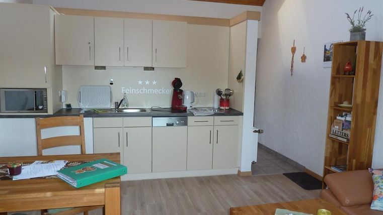 A cozy kitchen with modern design and wooden details. The dining area is simply furnished and inviting.