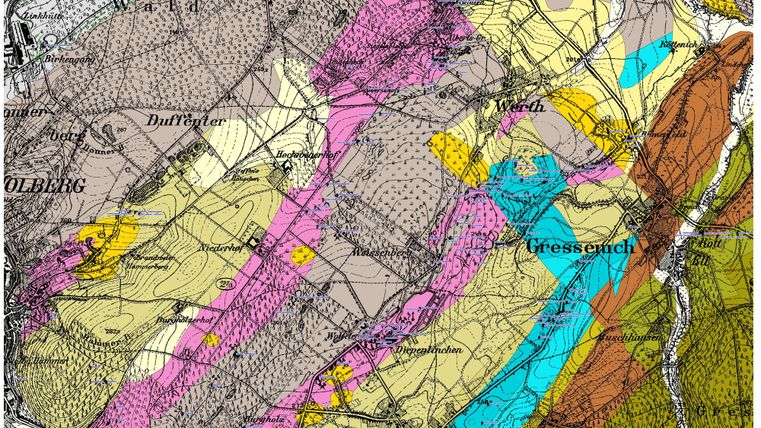 A historical geological map with various colors representing different types of rocks. The map also displays geographical names and lines that mark the terrain.