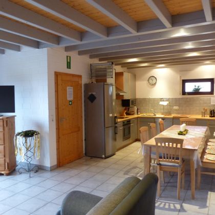A cozy kitchen with modern appliances and a dining table. The living area is bright and invitingly designed.