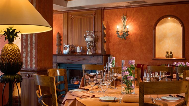 Een gezellig restaurant met warme tinten en elegante tafelversieringen. De sfeer wordt benadrukt door zacht licht en smaakvolle details.