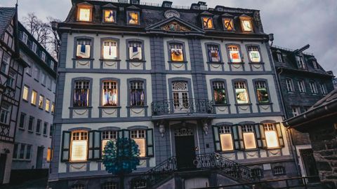 A historic building with colorful windows and a beautiful facade. The evening sky is gray and gives the scene a calm atmosphere.