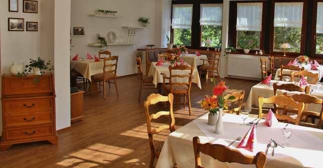 Een gezellig restaurant met heldere ramen en smaakvol gedekte tafels. De warme houttonen creëren een uitnodigende sfeer.