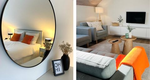 Een stijlvolle slaapkamer met een grote spiegel en een comfortabel bed. In de woonkamer staan moderne meubels en decoratieve elementen.