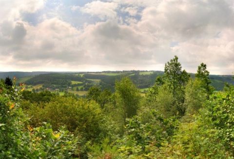 A picturesque landscape with green trees and gentle hills. The sky is cloudy, creating a serene atmosphere.