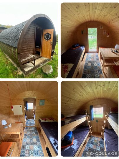 Een gezellige houten hut met een ronde vorm en een houten veranda deur. Binnen zijn er twee slaapruimtes met kleurrijke vloerbedekking en eenvoudige meubels ingericht.