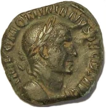 An antique coin featuring the portrait of a Roman emperor. The edge of the coin displays Latin inscriptions.
