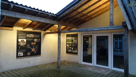 A covered entrance area with large windows and informative poster walls. The lighting creates an inviting atmosphere at dusk.