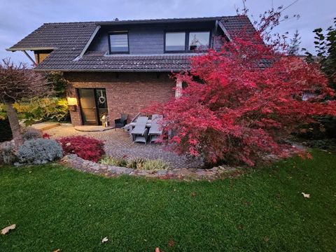 Een charmant huis met een onderhouden tuin. Een mooie rode boom zorgt voor herfstkleuren.