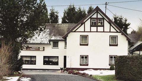 A charming country-style house with a bright exterior. Surrounded by trees and a small garden.
