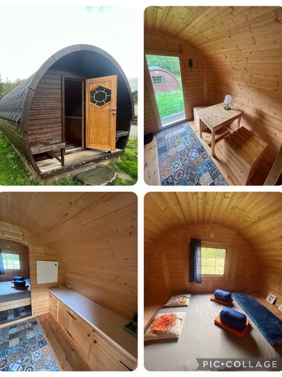 Een gezellig houten huis in de natuur. Binnen is het eenvoudig en uitnodigend met een tafel, matrassen en kleurrijke vloerbedekking.