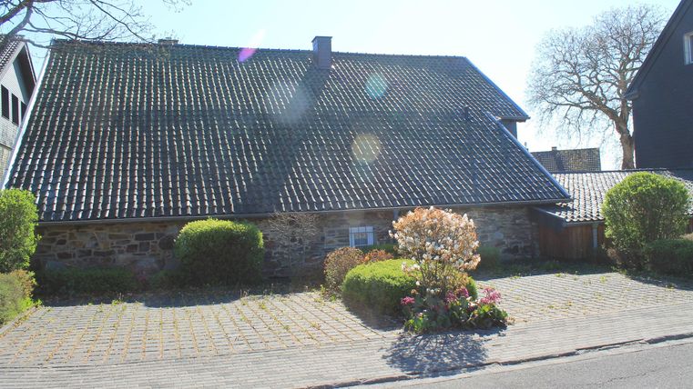 A charming house with a gabled roof and a beautiful garden landscape. The surroundings are calm and inviting, perfect for relaxed strolls.