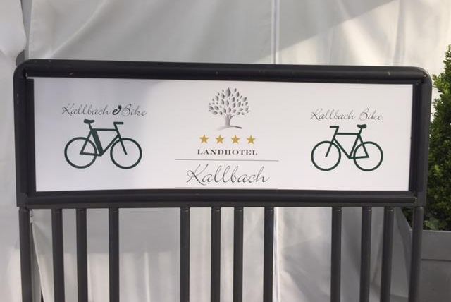 Ein Schild mit dem Schriftzug "Landhotel Kallbach" und zwei Fahrradsymbolen. Es vermittelt eine einladende Atmosphäre für Radfahrer.