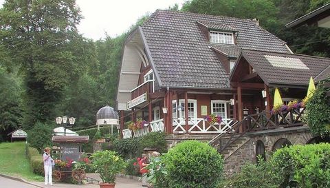 Ein charmantes Fachwerkhaus inmitten von Bäumen. Der Eingangsbereich ist mit bunten Blumen geschmückt und lädt zum Verweilen ein.