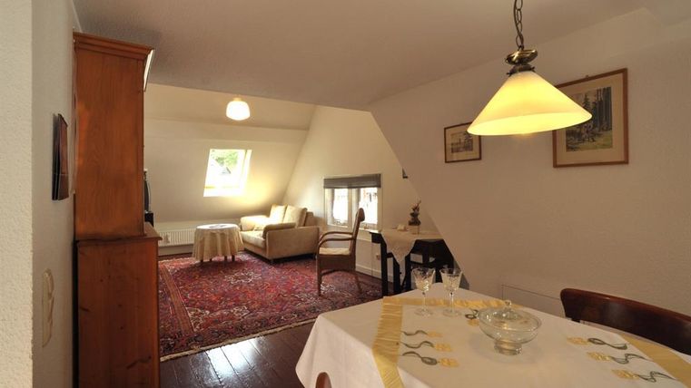Een gezellige woning met een eetgedeelte en een woonkamer. De ruimte heeft warme kleuren en veel daglicht.