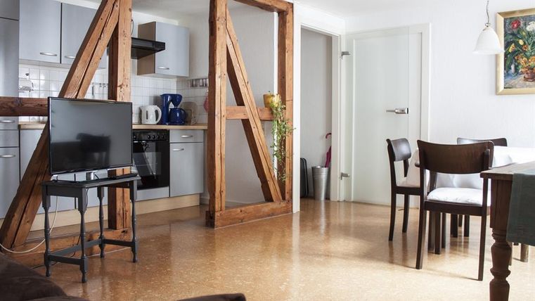 Een gezellige woning met een open keuken en modern meubilair. De woonkamer is licht en uitnodigend, ideaal voor ontspanning en gezellig samenzijn.
