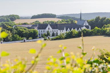 Blick auf das Kloster Mariawald umringt von sommerlicher Natur