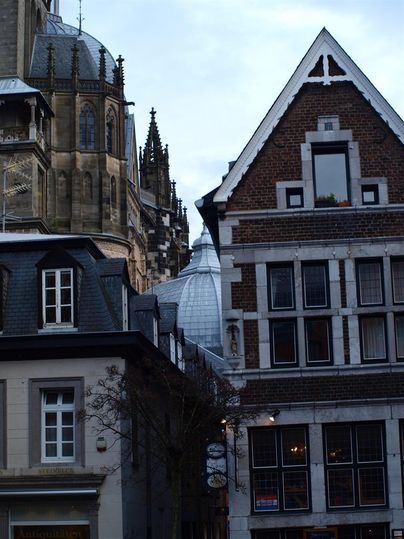 A cityscape with old buildings and a modern roof. The architecture showcases a blend of historical and contemporary styles.