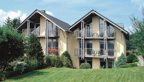 Twee moderne huizen met balkons in een groene tuin. Omgeven door bomen en struiken, stralen ze een rustige woonatmosfeer uit.