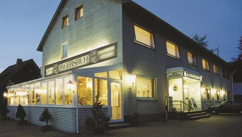 Een gezellig restaurant met een uitnodigende façade in avondverlichting. Het gebouw is helder verlicht en heeft grote ramen die uitzicht bieden op het interieur.