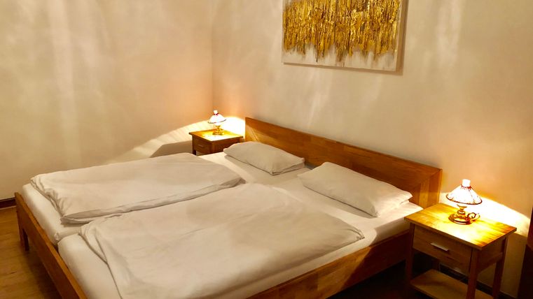 Ein gemütliches Schlafzimmer mit einem Doppelbett und zwei Nachttischen. Sanfte Beleuchtung und dekorative Wandkunst sorgen für eine einladende Atmosphäre.