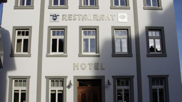 A modern building with the signage "Hotel" and "Restaurant" on the facade. The windows are bright and invitingly designed.